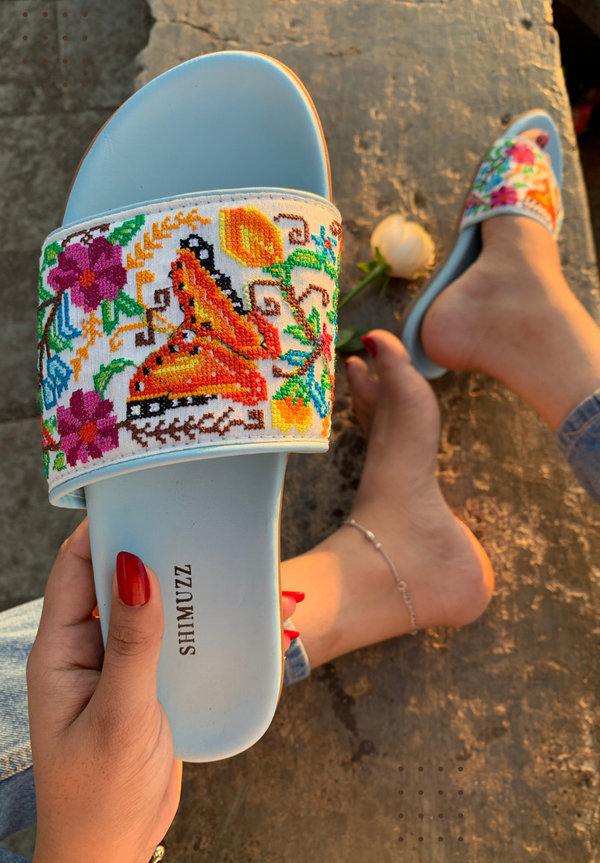 Girl wearing Hayaat Blue Sliders with blue denim jeans sitting at Bandra bandstand