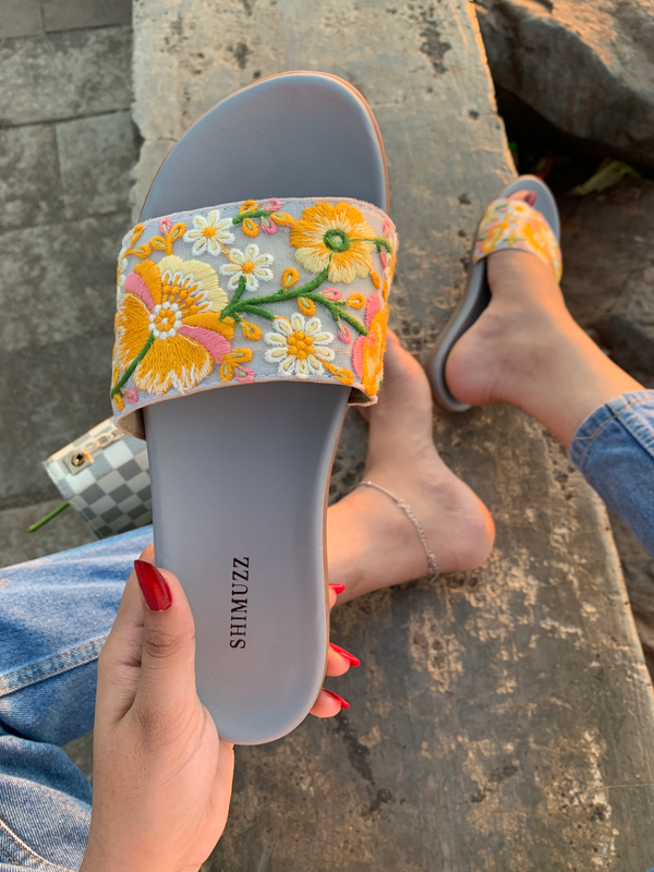 Girl wearing Naaz Sliders wearing denim jeans sitting down, bandra bandstand